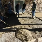 Crew pouring and screeding a concrete patio in Arvada, Colorado